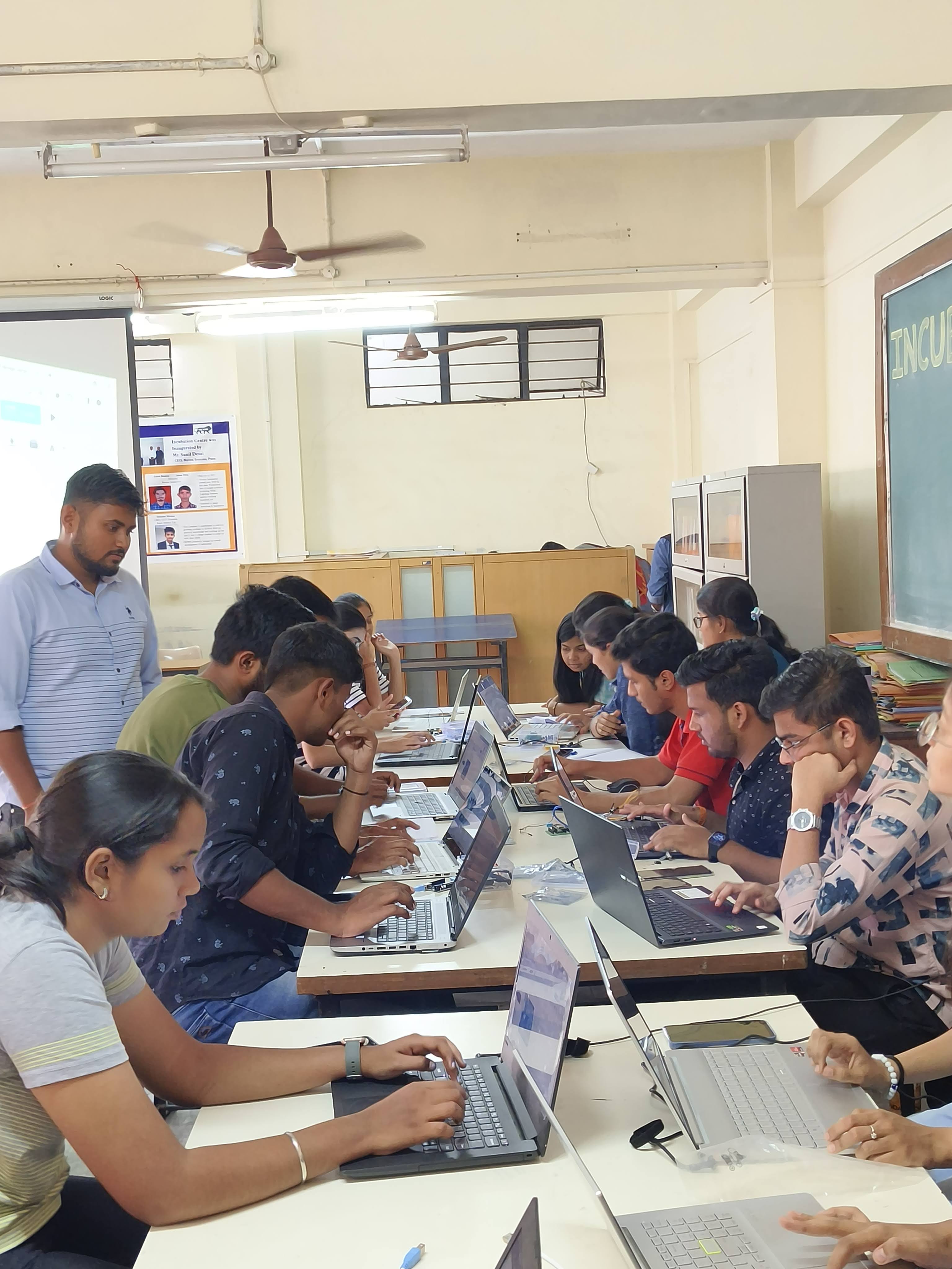 Students discussing Arduino and ESP32 programming during an IoT workshop